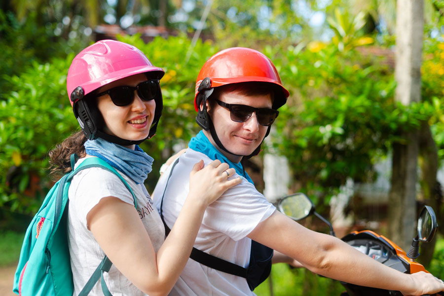 A-foreign-young-couple-riding-a-bike-wearing-helmets-as-it-is-one-of-the-things-that-you-should-NOT-avoid-to-make-your-stay-amazing-and-hassle-free-in-Sri-Lanka